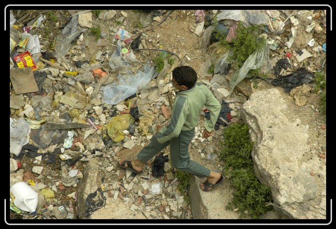 BoyStepsTrash5146 Into a pit, now filled with trash, then into a tunnel to a pool, once a village water supply