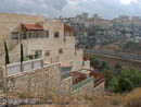 Settlement in foreground, Palestinian community in background, wall between